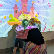 Young girl with mother in front of interactive projector in Austin Health Paediatric Emergency Department